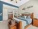 Spacious bedroom featuring a wooden bed frame, tray ceiling, and ensuite bathroom access at 14209 Quintessa Ln, Lithia, FL 33547