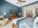 Well-lit bedroom with a ceiling fan, a TV, and access to an ensuite bath at 14209 Quintessa Ln, Lithia, FL 33547