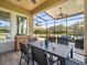 Relaxing screened-in patio with ceiling fan, comfortable seating, and a dining area at 14209 Quintessa Ln, Lithia, FL 33547