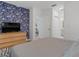 Modern bedroom with blue leaf wallpaper, wood dresser, and view to the ensuite bathroom at 1432 19Th S St, St Petersburg, FL 33712