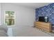Cozy bedroom with a large window and a blue leaf wallpaper wall with a wood dresser at 1432 19Th S St, St Petersburg, FL 33712