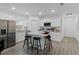Bright, open kitchen with stainless steel appliances, gray wood floors, and center island with granite countertop at 1432 19Th S St, St Petersburg, FL 33712
