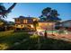 Dusk view of the backyard featuring a pool, patio, and well-manicured lawn at 14344 83Rd Pl, Seminole, FL 33776
