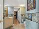Unique bathroom with tiled accent wall, decorative mirror, and a view through the doorway at 14344 83Rd Pl, Seminole, FL 33776