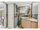 Quaint bathroom featuring custom accent tiles, vanity, mirror, and a view to the beautiful outdoor pool at 14344 83Rd Pl, Seminole, FL 33776