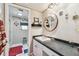 Clean bathroom with a shower, white tiled walls, and a decorative mirror at 14344 83Rd Pl, Seminole, FL 33776