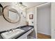 Cozy bathroom with a unique round mirror, black countertops, and neutral-toned walls at 14344 83Rd Pl, Seminole, FL 33776