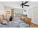 Well-lit bedroom showcasing a ceiling fan, window with blinds, hardwood floors, and comfortable bedding at 14344 83Rd Pl, Seminole, FL 33776