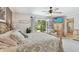Bedroom with backyard access, TV, and ceiling fan; adjacent to ensuite bathroom at 14344 83Rd Pl, Seminole, FL 33776