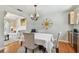 Dining area features gray upholstered chairs, dining table with white tablecloth, and hardwood floors at 14344 83Rd Pl, Seminole, FL 33776