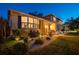 Inviting two-story home with manicured lawn, stone accents, and warm exterior lighting at dusk at 14344 83Rd Pl, Seminole, FL 33776