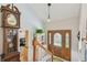 Grand foyer with grandfather clock, staircase, and entryway with stained glass door panels at 14344 83Rd Pl, Seminole, FL 33776