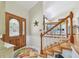 Inviting foyer with decorative rug, stained glass accents, and wooden staircase at 14344 83Rd Pl, Seminole, FL 33776