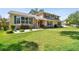 Inviting home exterior showcasing lush green lawn, tidy landscaping, and charming architectural details at 14344 83Rd Pl, Seminole, FL 33776