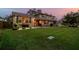 Well-maintained home with lush lawn, landscaping, and exterior stone accents at dusk at 14344 83Rd Pl, Seminole, FL 33776