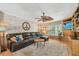 Cozy living room featuring a large leather sectional sofa, plush carpet, and entertainment center at 14344 83Rd Pl, Seminole, FL 33776