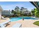 A beautiful pool area features chaise lounges and a lush backyard at 14344 83Rd Pl, Seminole, FL 33776