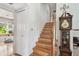 Bright stairway featuring hardwood stairs and floors, accented by a classic grandfather clock at 14344 83Rd Pl, Seminole, FL 33776