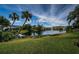 Scenic backyard view of the lush landscaping and a tranquil lake at 1522 Riverdale Dr, Oldsmar, FL 34677