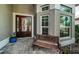 Inviting front porch area with an elegant stained-glass front door and a comfortable bench at 1522 Riverdale Dr, Oldsmar, FL 34677