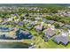 An elevated view of a home with a screened pool, surrounded by lush greenery and a serene lake at 16529 Ivy Lake Dr, Odessa, FL 33556