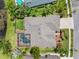 Bird's-eye view of a home featuring a screened pool, well-kept lawn, and meticulously landscaped surroundings at 16529 Ivy Lake Dr, Odessa, FL 33556