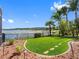 Expansive backyard with lush lawn, lake view, and tropical landscaping, creating a serene outdoor retreat at 16529 Ivy Lake Dr, Odessa, FL 33556