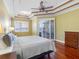 Bright bedroom features trey ceiling, fan, wood floors, and sliding glass doors to the lanai at 16529 Ivy Lake Dr, Odessa, FL 33556