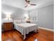 Bedroom with hard wood floors, a ceiling fan, and well-lit nightstands at 16529 Ivy Lake Dr, Odessa, FL 33556
