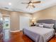 Bedroom with hardwood floors, ceiling fan, and access to balcony with lake views at 16529 Ivy Lake Dr, Odessa, FL 33556