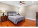 Bedroom with hardwood floors, ceiling fan and view of the backyard at 16529 Ivy Lake Dr, Odessa, FL 33556