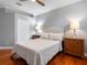 Bedroom with hardwood floors, a ceiling fan and lamps on the nightstands at 16529 Ivy Lake Dr, Odessa, FL 33556