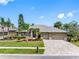 Charming single-story home with a three-car garage, stone accents, and lush landscaping in a suburban neighborhood at 16529 Ivy Lake Dr, Odessa, FL 33556