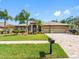An inviting home exterior boasts a manicured lawn, verdant landscaping, and a stately three-car garage at 16529 Ivy Lake Dr, Odessa, FL 33556