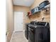 Well-equipped laundry room with modern washer and dryer, storage shelves, and convenient access at 16529 Ivy Lake Dr, Odessa, FL 33556
