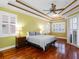 Bright main bedroom with hardwood floors, a tray ceiling, and large windows with plantation shutters at 16529 Ivy Lake Dr, Odessa, FL 33556