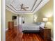 Spacious main bedroom featuring hardwood floors, a tray ceiling, and access to an ensuite bathroom at 16529 Ivy Lake Dr, Odessa, FL 33556