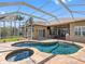 Gorgeous screened-in pool area, featuring a spa and lush landscaping for a private outdoor oasis at 16529 Ivy Lake Dr, Odessa, FL 33556