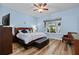 Comfortable bedroom with wood-look floors, ceiling fan and window with green outdoor view at 19026 Dove Creek Dr, Tampa, FL 33647