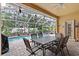 Screened-in patio perfect for outdoor dining with a view of the sparkling pool and lush landscaping at 19026 Dove Creek Dr, Tampa, FL 33647