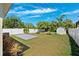A spacious, well-manicured backyard features lush green grass, a white fence, shed, and concrete patio at 2410 26Th S St, St Petersburg, FL 33712