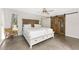 Cozy bedroom featuring wooden floors, unique barn door, and comfortable bed at 24549 Nova Ln, Punta Gorda, FL 33980