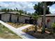 Beautifully landscaped home exterior showcasing a patterned walkway and thriving tropical plants at 24549 Nova Ln, Punta Gorda, FL 33980