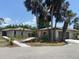 Contemporary home exterior with well-kept landscaping, palm trees, and a paved pathway at 24549 Nova Ln, Punta Gorda, FL 33980