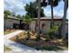 Beautifully landscaped front yard featuring tropical foliage, stone walkway, and a glimpse of the home's facade at 24549 Nova Ln, Punta Gorda, FL 33980
