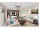 Bright living room featuring modern built-ins, neutral furniture, and ample natural light from the large windows at 24549 Nova Ln, Punta Gorda, FL 33980