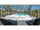 Relaxing view of a screened-in pool area with lounge chairs and clear blue water at 24549 Nova Ln, Punta Gorda, FL 33980