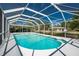 Enclosed pool features a bright blue swimming pool with seating area surrounded by lush greenery at 24549 Nova Ln, Punta Gorda, FL 33980