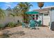 Inviting backyard featuring a cozy seating area with Adirondack chairs, complemented by lush palm trees and privacy fence at 2610 58Th S St, Gulfport, FL 33707