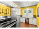 Bright yellow kitchen features stainless steel appliances, modern cabinets and a unique textured metal ceiling at 2610 58Th S St, Gulfport, FL 33707